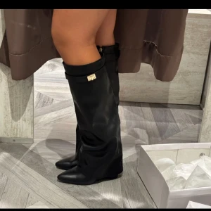 Svarta stövlar/klackar - Säljer nu dessa populära bootsen i skinn med spetsig tå. Stövlarna har en elegant rem med metallspänne upptill som ger en snygg detalj. 