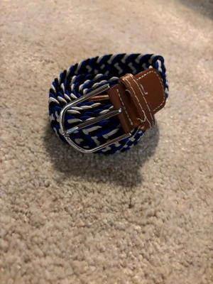 Flätat bälte blåt, vitt och svart - Flätat bälte bra andvänt fast har tagit hand om bra 👍 