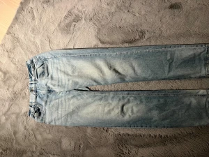 Ljusblå jeans från Lindex Stl 164 - Säljer ett par ljusblå jeans från Lindex med klassisk femficksdesign och elastisk midja. Jeansen har raka ben och är tillverkade i mjukt bomullsmaterial. Köpt för 300 kr. Stl 13-14 år (164). Bra skick. 