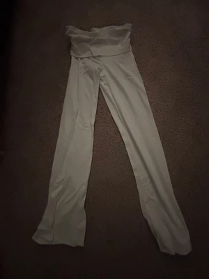 Vita mjukisbyxor från Gina Tricot - Säljer ett par vita mjukisbyxor från Gina Tricot i storlek 146/152. Byxorna har en bred, hög midja och raka ben med lite utsvängd nederdel. Materialet är mjukt och stretchigt, perfekt för chill dagar. Snygg och enkel design som är lätt att matcha.