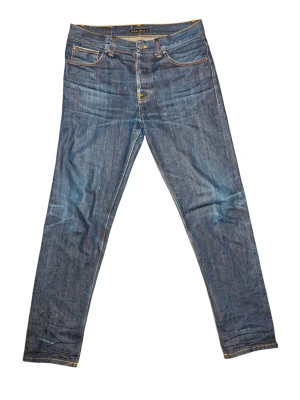 Nudie jeans steady eddie dry selvage fits w32 l34 - Tjena! Jag säljer nu dessa nudies i dry selvage som börjar utveckla fina fades redan nu. ◇Modell: steady eddie 2 (straight) Normal i storleken, men dessa passar även en w32. Kontaka mig vid mått om så önskas. Fint skick, inget att anmärka på utom ett fåtal droppar vax på framsidan (se bild) och en liten defekt vid skrevet som inte syns vid användning. Kan även repareras gratis hos nudie för den som önskar. ◇Kontakta mig vid frågor! ◇pris kan diskuteras (i viss mån)