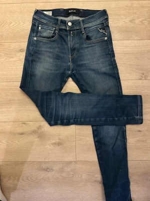 Replay Anbass jeans hyperflex  - Snygga Replay Anbass jeans hyperflex. Nypris 1600kr. Färgen är mörkblå och kontrastsömmar. Modellen har normal midja och raka ben med smal passform. Materialet är stretchigt jeans för skön komfort. Perfekt för dig som gillar sköna och stilrena jeans. Det står W28 L32 men skulle snarare säga W28 L 28-29 eftersom att de är av kortade. Be om mått vid funderingar av länd