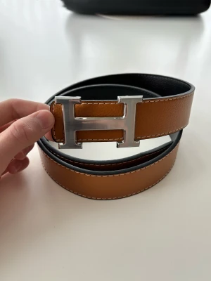 H bälte - Stilrent bälte med H-spänne. Reversable vilket betyder att man kan välja mellan svart och brunt. Helt oanvänt. Hör gärna av dig vid frågor eller funderingar
