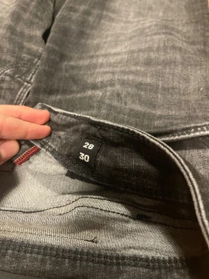 Grå slim jeans Jack & Jones 28/30 - Säljer ett par grå slim fit jeans från Jack & Jones, modell Glenn. Jeansen har klassisk femficksdesign, smal passform och snygg tvättad look. Perfekta för dig som gillar en modern och stilren vibe.