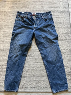 Tommy Jeans blå jeans straight fit - Snygga blå jeans från Tommy Jeans med klassisk rak passform. Jättebra skick, storlek 31/32