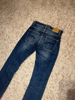 Nudie jeans grim tim slim fit herr fade w29 blå - Nudie jeans slim fit modell grim tim, unik wash. Mycket bra skick, inga märkvärdiga defekter. Storlek w29 L32.  postas antigen samma dag som köp eller dagen därpå🙌💯