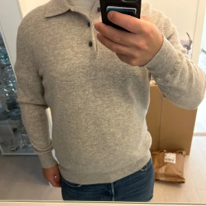 Tröja i ull - Säljer en stilig ljusgrå tröja med krage från Massimo dutti. Tröjan är aldrig använd är helt ny i skick. Tröjan är gjord i mjuk ull. Storleken sitter som en M till L.