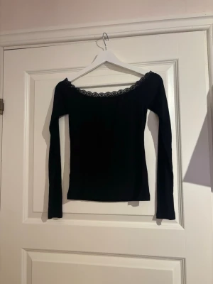 Svart långärmad topp med spetskant - En jättefin svart långärmad tröja med spets längst kanten. Från Bikbok i storlek Xs