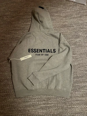 ESSENTIALS ”FEAR OF GOD” - Säljer nu min ljusgråa Essentials hoodie pga storleks fel. Tröjan är i Storlek L men lite för stor, så XL är nog den rätta storleken, pris är ej hugget i stan! Kom med prisförslag eller fler bilder!