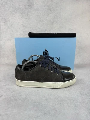 Lanvin DBB1 cap toe sneaker - – Condition: 8/10  - Size: 40/UK6  – What is included: Only the sneakers  – Retail price: 5500 + SEK  Please note that Lanvins fit big and our recommendation is to go one size down
