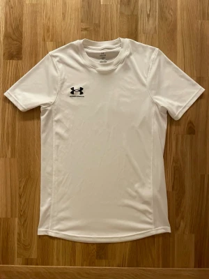 T-shirt Under Armour  -  En träningst-shirt från Under Armour i vit. Knappast använd och i gott skick samt inga defekter. Storlek: S