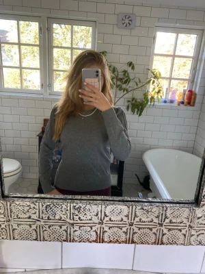 Grå stickad tröja från Saint Tropez - En enkel och stilren grå stickad tröja från Saint Tropez. Tröjan har rund halsringning, ribbade muddar och är långärmad. Perfekt att matcha med jeans eller kjol för en chill look.