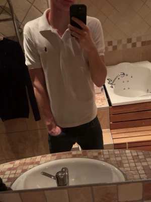 Vit pikétröja från Ralph Lauren - Säljer en klassisk vit pikétröja från Ralph Lauren med korta ärmar och krage. Passformen är riktigt bra.  Perfekt till jeans eller shorts. Tröjan har fläckar och är nopprig så kan gå med på lågt pris | Tveka inte med att höra av dig om minsta lilla fundering😌