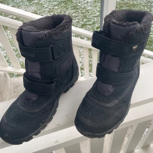 Svarta vinterboots från Timberland - Säljer ett par svarta vinterboots från Timberland med mjukt foder och kardborreband. Bootsens ovandel är i mocka och syntet. 
