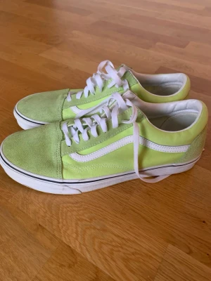 Limegröna Vans Old Skool sneakers - Säljer ett par Vans Old Skool sneakers i limegrönt med vita detaljer och klassisk sidorand. Ovandelen är i mocka och canvas, med gummisula undertill. Perfekt för dig som gillar färg och streetstyle.