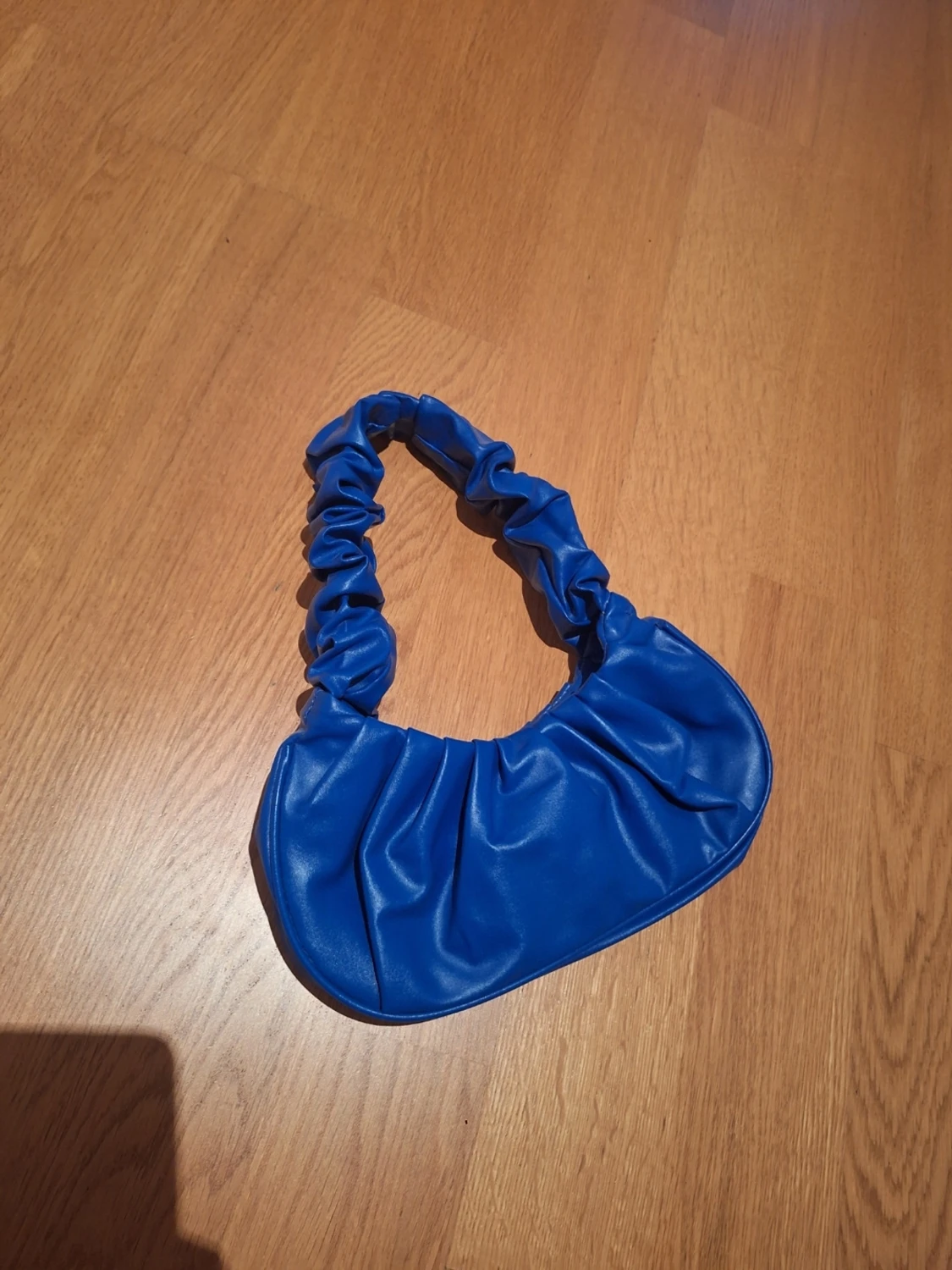 Blå axelväska med rynkad rem