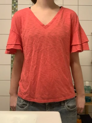 Rosa volangärmad topp  - Säljer en rosa topp från INC International Concepts i storlek S. Toppen har v-ringning och korta ärmar med dubbla volanger. Materialet är mjukt och lätt, perfekt för varmare dagar.