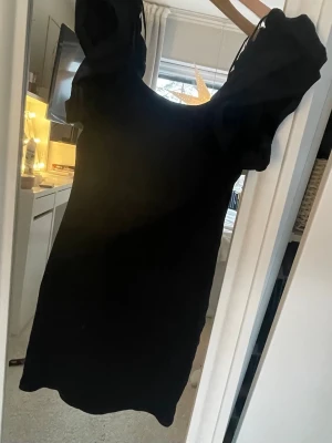 Svart kort klänning från H&M Divided - Säljer en svart kort klänning från H&M Divided i storlek XS. Klänningen har puffiga korta ärmar och en rundad urringning både fram och bak. Pris går att diskuteras vid köp❤️