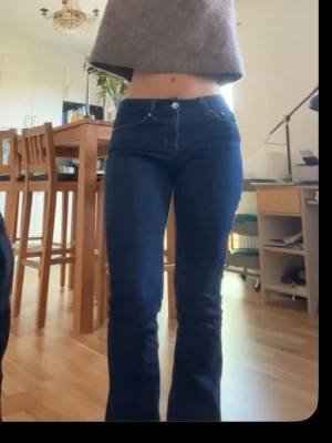 Mörkblå bootcut jeans - Snygga mörkblå jeans med bootcut-snitt och klassisk femficksdesign. Jeansen har låg midja och är tillverkade i ett stretchigt denim-material som sitter skönt och formar benen. Perfekta för dig som gillar en retro vibe och vill ha ett par jeans som sticker ut. Är lite slitna där nere men inget som syns särskilt mycket, är 162😊