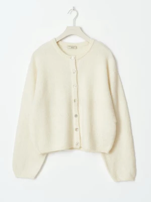 Vit kofta från Gina tricot - Mysig vit kofta från & Gina tricot med rund hals och knappar framtill. Passar även till mig som brukar ha storlek m.Koftan har långärmade ärmar och är stickad i mjukt material som känns skönt mot huden. Perfekt att slänga på sig när det är lite kyligt ute. Andvänt några gånger men fortfarande i väldigt bra kvalitet. Säljer för att den inte användes så mycket längre 