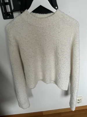 Vit fluffig stickad tröja från Monki - Säljer en supermjuk och fluffig vit stickad tröja från Monki. Tröjan har en rak, något kortare passform, rund halsringning och långa ärmar. 