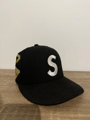 Supreme keps - Säljer nu min riktigt feta supreme keps. Kepsen är i väldigt bra skick och har en riktigt snygg detalj på sidan! Måttet är 56.8cm
