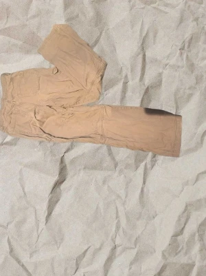 Beige cargopants med fickor - Snygga beige cargopants med flera praktiska fickor på sidorna. Byxorna har en avslappnad passform och är perfekta för en chill och trendig stil. Tillverkade i bomull för skön känsla hela dagen.