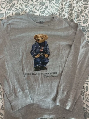 Grå långärmad Polo Bear tröja - Säljer en grå långärmad tröja från Ralph Lauren. Aldrig använt 
