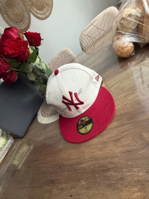 Lucid Keps - Snygg New Era 59Fifty keps med New York Lucid Yankees-logga i rött framtill. Kepsen är vit med röd skärm och broderade detaljer. Klassisk flatbrim-modell i bomull, perfekt för dig som vill ha en stilren och sportig look.