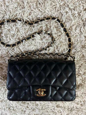 Svart axelväska - Elegant svart CC axelväska. Tidlös design, perfekt till både vardag och fest. I mycket gott skick✨Skriv till mig vid frågor😇