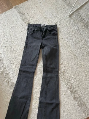 Svarta bootcut jeans  - Snygga svarta bootcut jeans med klassisk femficksdesign och normal passform. Jeansen har en mörk tvätt och är tillverkade i mjukt bomullsmaterial med lite stretch för extra komfort. Perfekta för dig som gillar en tidlös och trendig look.