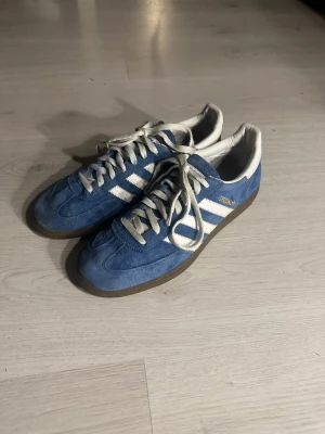 Adidas special  - Säljer ett par blå Adidas Special sneakers i mocka med vita ränder och snörning. Klassisk retrostil som passar perfekt till streetwear och vardagsoutfits. Skorna är i bra skick men tecken på användning finns. Skriv vid frågor och kolla gärna in min profil för potentiella bundles 💸