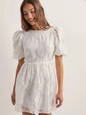 Studentklänning Vit kort klänning med puffärm - Superfin vit kort studentklänning med puffärmar och broderade blommor . Klänningen har rund halsringning och markerad midja för en söt siluett. Klänningen är öppen i ryggen men knyts ihop med ett sött band. Perfekt till studenten eller sommaren! Aldrig använd, köpt från Nelly storlek 38.💞