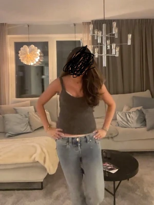 Mörkgrå stickad linnetopp - Säljer en mörkgrå stickad linnetopp med v-ringning och breda axelband. Toppen har en croppad passform och är perfekt att styla med jeans eller kjol. Materialet är mjukt och lite luddigt vilket ger en mysig känsla.