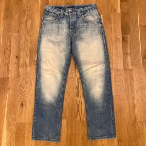 Nudie jeans Big Bengt - Säljer ett fett par Nudie jeans i modellen big Bengt, som inte tillverkas längre. Står att storleken är 30/34 men passar som 30/30.                                                                                     Längd 99cm                                       Midja 40cm                             Benöppning 18,5                                           De är i fint skick. Hör av dig vid intresse eller frågor