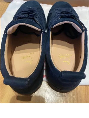 Mörkblå sneakers från Christian Louboutin - Säljer ett par riktigt snygga Christian Louboutin skor! Skorna är i mycket bra skick och har inga defekter. Allting på bilderna tillkommer. Om ni har några frågor så är de bara att höra av er😊 ANVÄNDA ENDAST 3-4 gånger ute