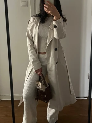 Vida beige byxor och topp i ribbat material - Säljer ett par vida beige byxor och kortärmad topp  i ribbat material. Byxorna har hög midja och en avslappnad passform som ger en chill vibe, samma med toppen ! 