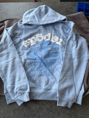 Ljusblå Sp5der Hoodie - Storlek: S Har aldrig använt tröjan någonsin och den är helt ny! Startpris: 550kr