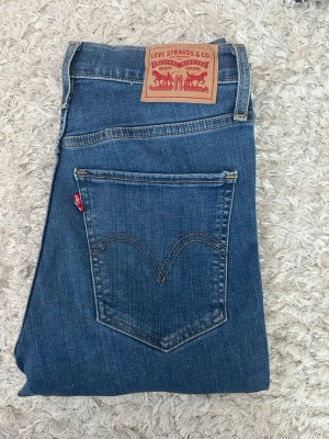 Levi's Mile High Super Skinny jeans blå W27L30 - Snygga blå Levi's Mile High Super Skinny jeans med hög midja och klassisk femficksdesign. Jeansen har en smal passform och är tillverkade i stretchigt denim för extra komfort. Perfekta för dig som gillar en tight och modern look.