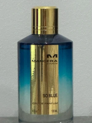 Mancera So Blue Eau de Parfum 120ml - Mancera So Blue Eau de Parfum i en snygg cylinderformad glasflaska med blått till genomskinligt färgskiftande design och guldfärgat metallock. Flaskan rymmer 120 ml och har en lyxig guldig etikett framtill med svart text. Använt bara ett fåtal spray. Självklart äkta