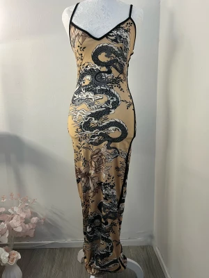 Klänning - Sjukt snygg långklänning med figurnära passform från Fashion Nova. Klänningen har smala svarta axelband och v-ringad hals. Storlek XS men passar även S i och med stretchigt material. Använd en gång och i utmärkt skick. 🤎