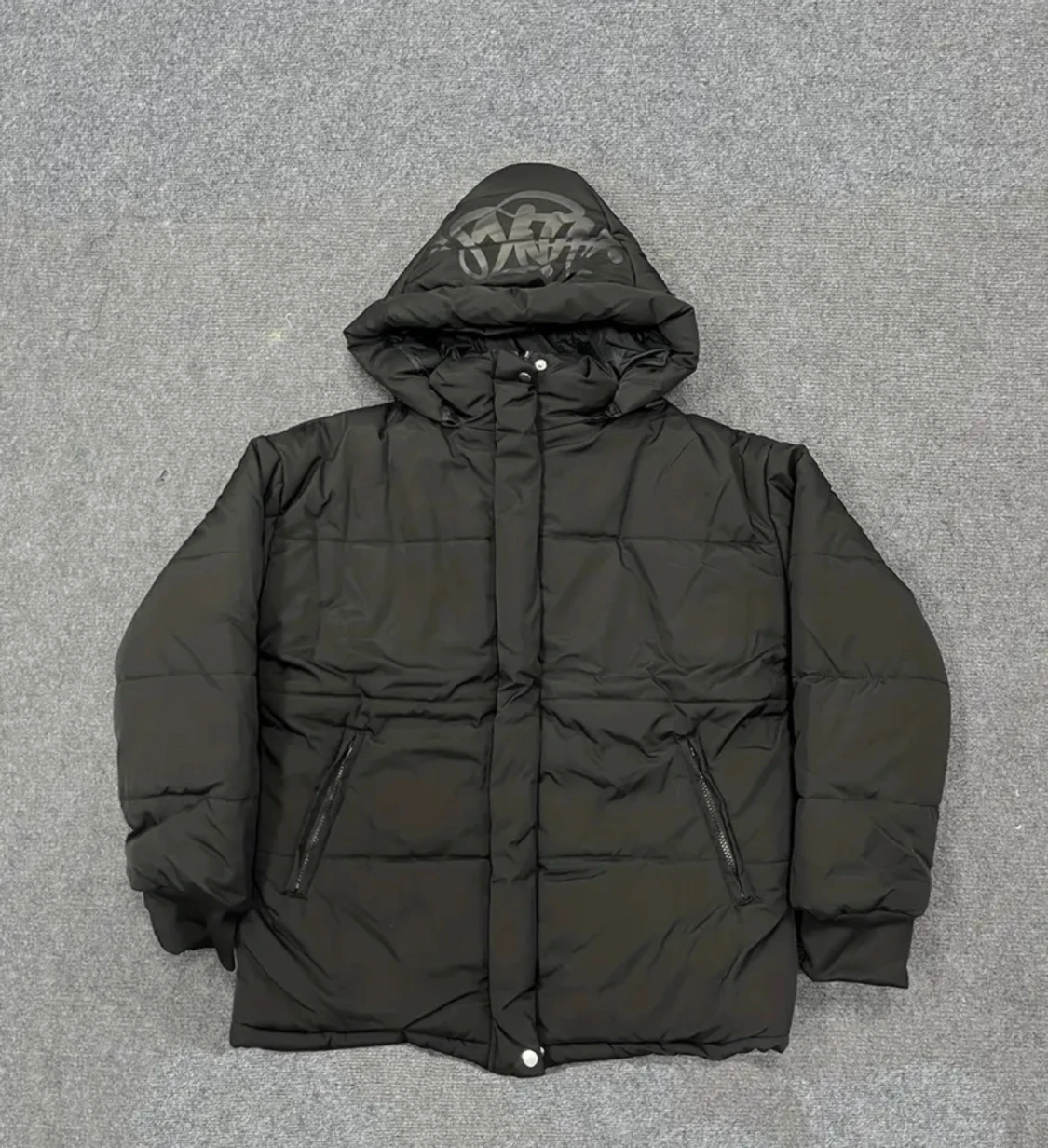 Svart pufferjacka med tryck på huvan