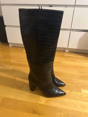 Höga stövlar med klack - Snygga höga spetsiga stövlar med klack. Kommer från hm, inga skavanker, enbart testade. Mönstrade. Storlek 40. Perfekt för fest eller utgång.