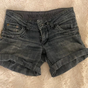 Grå y2k shorts - Snygga gråa shorts men kontrast och snygga detaljer, lite defekter på baksidan (se bilder), men lägger snygga detaljer på. I storlek ”34” men mer som 36, midjemåttet är 76 cm. Från märket ”yeansplease”❤️🫶