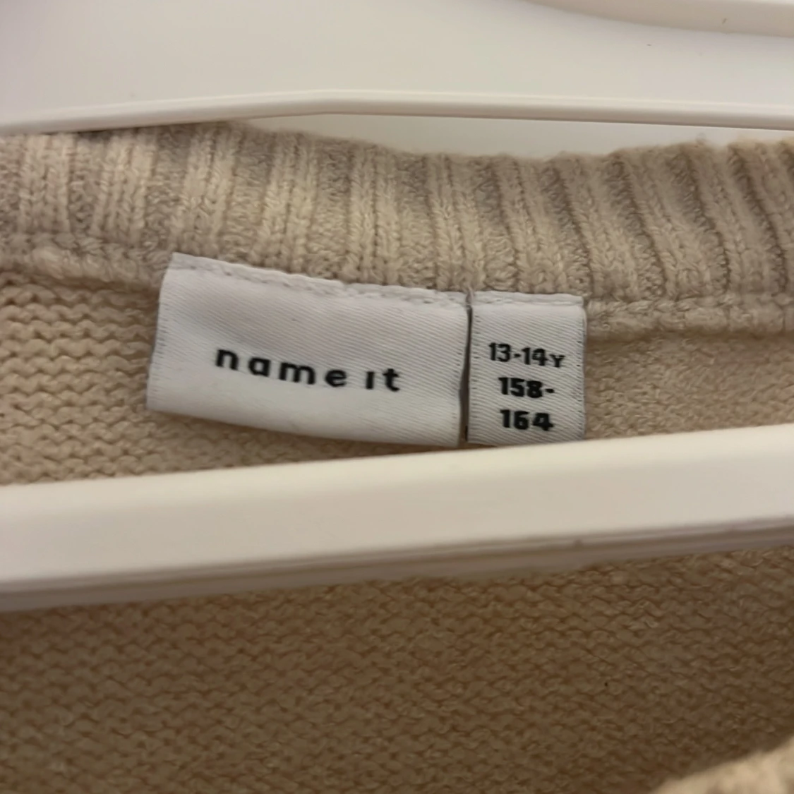 Beige stickad tröja med svarta rosetter - 1