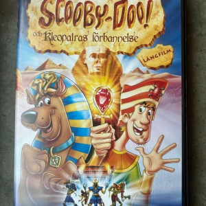 Scooby doo och kleopatras förbannelse DVD - Följ med Scooby-Doo och gänget på ett spännande äventyr i Egypten där de löser mysteriet med Kleopatras gravkammare. Denna långfilm bjuder på spänning och humor för hela familjen.  Finns på språk: Svenska, Finska, Norska, Engelska  OBS!! skivorna är begagnade så det kan förekomma repor/hairlines på skivorna, men då jag kollar igenom alla filmer jag säljer garanterar jag att alla funkar felfritt om inget annat står! 