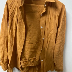 Gul dress - Snygg gul dress  med klassisk krage och vita knappar. Skjortan har lång ärm och avslappnad passform, perfekt för en trendig och bekväm look. Enkel att styla med både jeans och shorts.