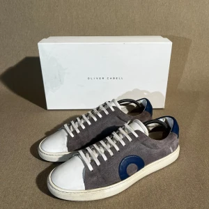 Oliver Cabell - En av de populäraste skorna på marknaden av en anledning. Unika skor med en perfekt design.  Storlek: 41 | Färg: Grå & Vit | Skick: Mycket bra (små tecken på toe capen & insidan) | Material: Mocka | Tillbehör: Box, Dustbag & Kvitto | Pris: 1999kr | Dm för frågor.