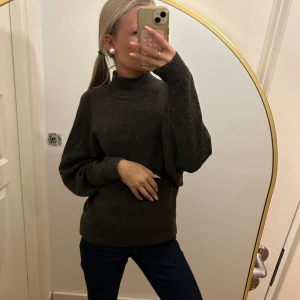 Mörkbrun stickad polotröja - Säljer en mörkbrun stickad polotröja med hög hals och långa ärmar. Tröjan har en loose passform och är perfekt för dig som gillar en chill och enkel stil. Materialet är mjukt och skönt mot huden och passar bra till jeans eller andra favoritplagg.