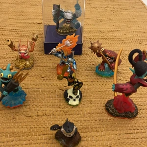 Skylanders figurpaket - Åtta Skylanders-figurer i färgglada designer, inklusive en figur i originalförpackning. Perfekt tillbehör för Skylanders-spel. Figurerna är i fint skick med endast mindre spår av användning. Samlarobjekt för både lek och display.
